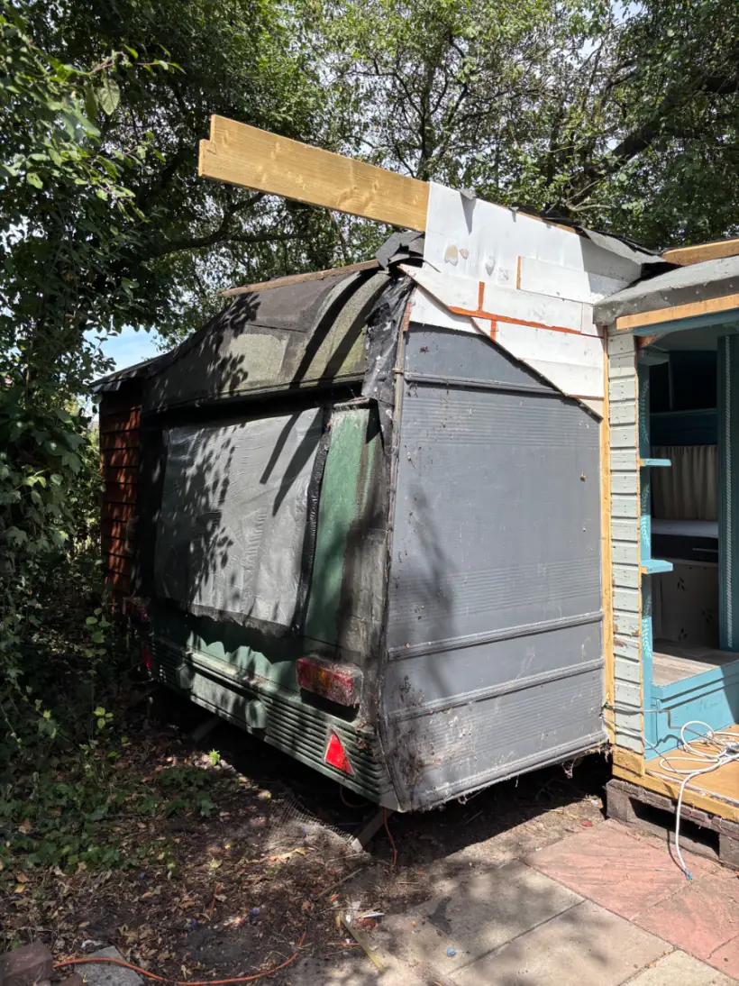 Caravan collapsed in on itself with the roof caved and one side burnt through, far past towing and squarely a break-up-on-site job