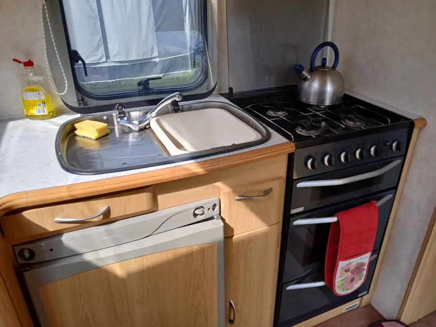 Caravan kitchen unit with a kettle on the hob and a stainless sink, the mix of timber, metal and plastic that has to be separated after a Dunstable collection