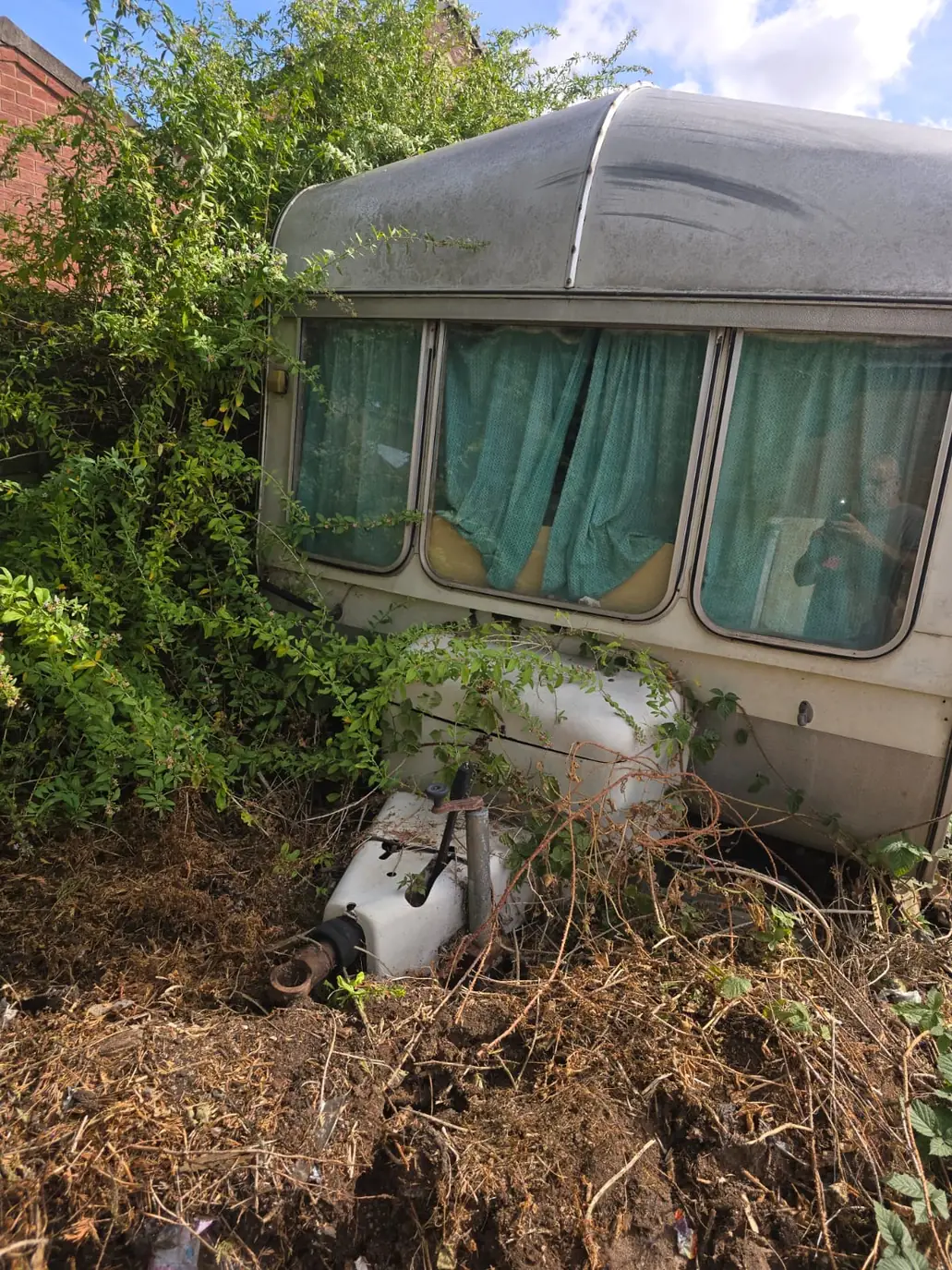 Derelict caravan sunk into overgrowth after years left unused