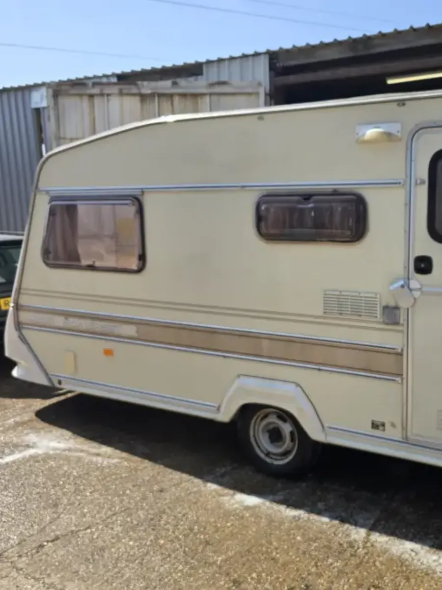 Side view of a cream 1980s touring caravan with its wheels on and bodywork sound, the condition detail an offer is built from