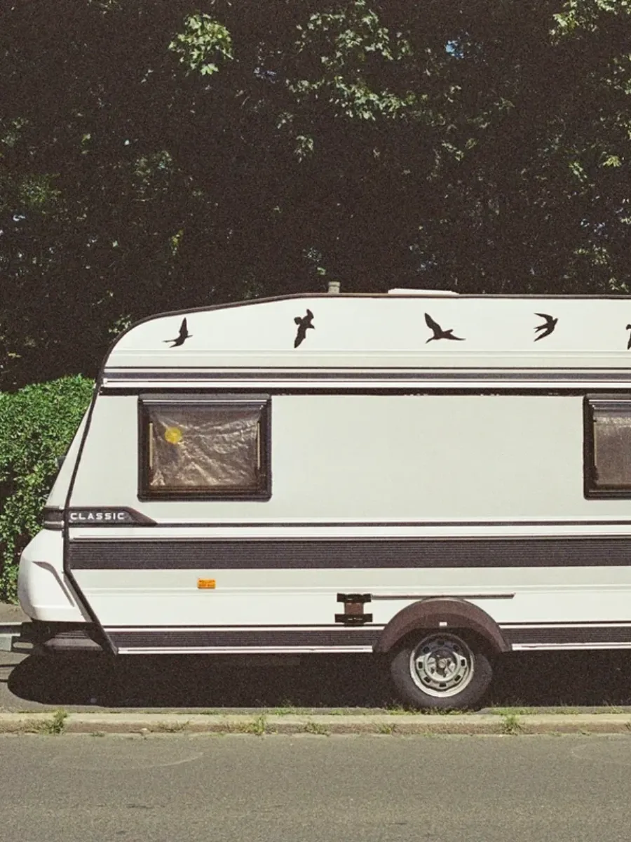 White touring caravan parked kerbside on a quiet road, tidy and complete, the sort of tourer owners would otherwise advertise privately