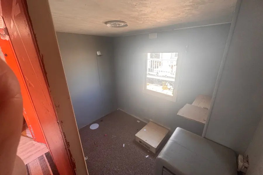 Caravan interior stripped back to bare walls and floor with the fittings already out, part-way through being separated into its recycling streams